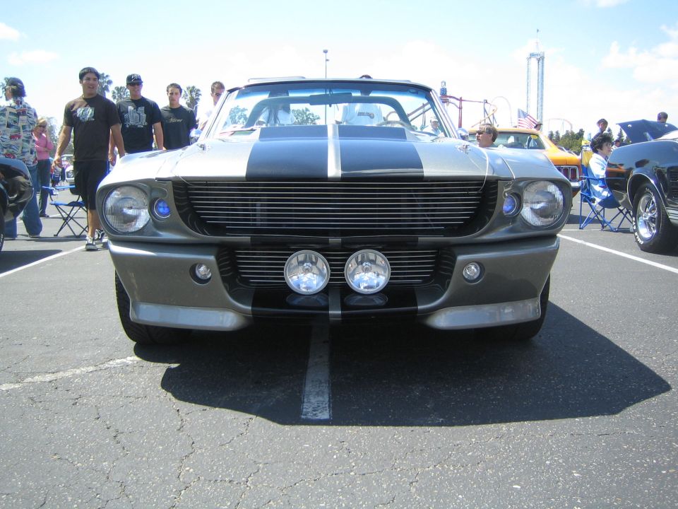 Front view of a gray Shelby GT500 with black stripes and fog lights