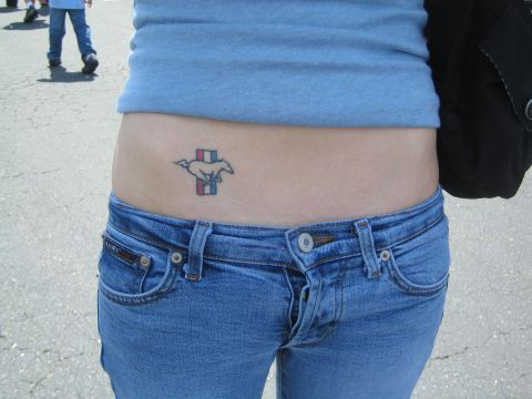 1968 Ford Mustang - A tattoo of the iconic Ford Mustang logo is visible on a person's hip.