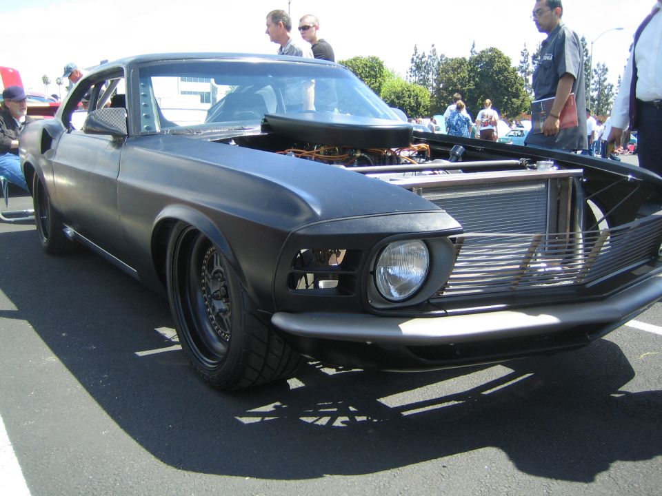 Black matte 1969 Ford Mustang with hood open, showing engine and radiator