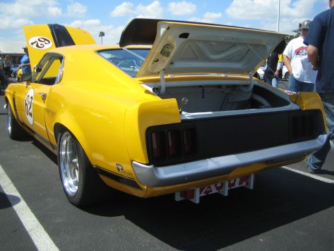 1968 Ford Mustang - A yellow 1969 Ford Mustang Boss 302 race car is displayed with its hood and trunk open.