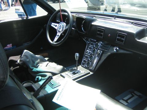 1968 Ford Mustang - The interior of a classic car features a distinctive dashboard and shifter, with a document on the console.