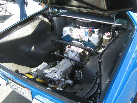 1968 Ford Mustang - The engine bay of a blue car reveals a V8 engine, transmission, and air filter, with a license plate reading 5DO5877.