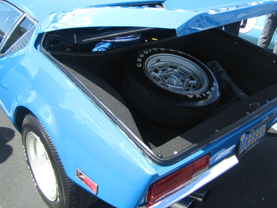 Blue coupe trunk with spare tire and Good Year Arriva tire