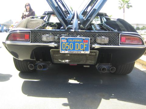 1968 Ford Mustang - Rear view of a black De Tomaso Mangusta, quad exhaust pipes and a California license plate reading '050 DCF'.