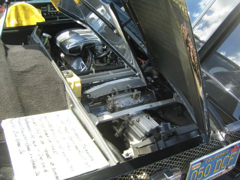1968 Ford Mustang - Car's engine bay is open, showing the engine and components. A handwritten note is placed nearby.