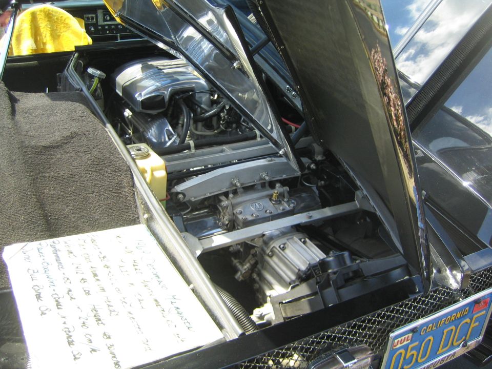 Engine bay of a car with handwritten notes on a piece of paper. California license plate 050 DCF is visible