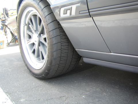 1968 Ford Mustang - Close-up of a gray Ford Mustang GT's side profile, showing its wheels and GT badging.
