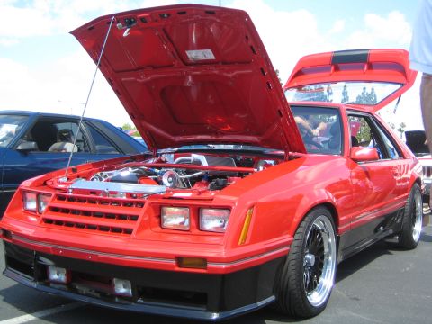 1968 Ford Mustang - A red Mustang with its hood and trunk open is displayed at an outdoor car show.