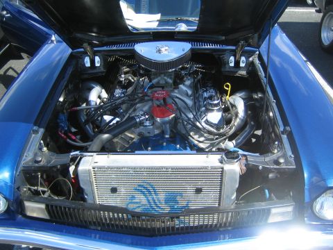 1968 Ford Mustang - Engine bay of a blue 1968 Ford Mustang, showing a V8 engine and custom radiator.