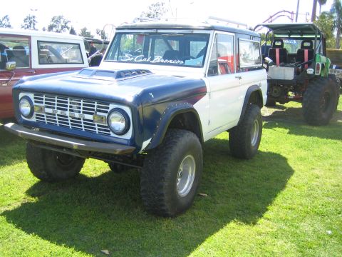 1968 Ford Mustang - Modified Ford Bronco with custom hood scoop and off-road tires, parked next to another vehicle.