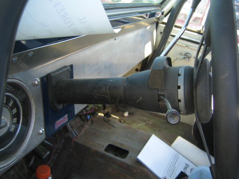 1968 Ford Mustang - Close-up view of the steering column and dashboard of a vehicle, with some papers on the dash.