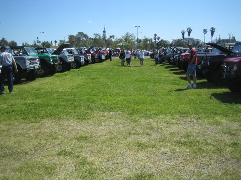 1968 Ford Mustang - A gathering of off-road vehicles displayed on a grassy field under a clear blue sky.