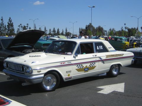 1968 Ford Mustang - A white 1963 Ford Galaxie drag car is parked in a lot with other vehicles under a clear blue sky.