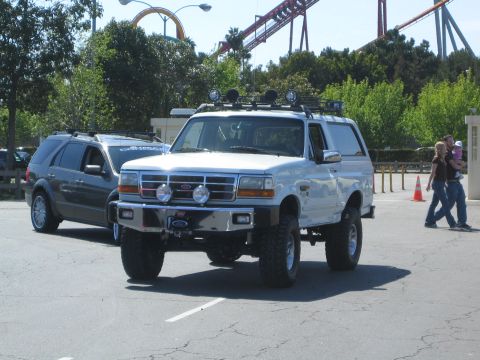 1968 Ford Mustang - A white Ford Bronco with off-road modifications is parked in a lot, with another SUV visible behind it.
