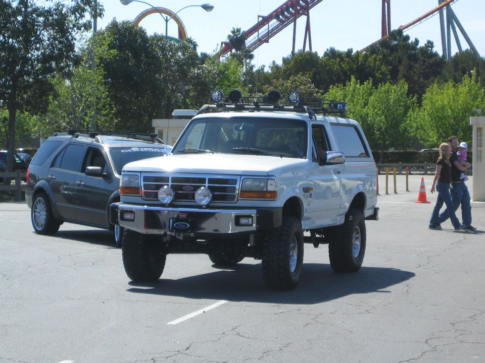 White 1996 Ford Bronco with aftermarket bumper and lights