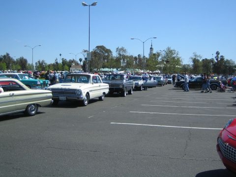 1968 Ford Mustang - A car show features a variety of vintage automobiles parked in rows under a clear blue sky.