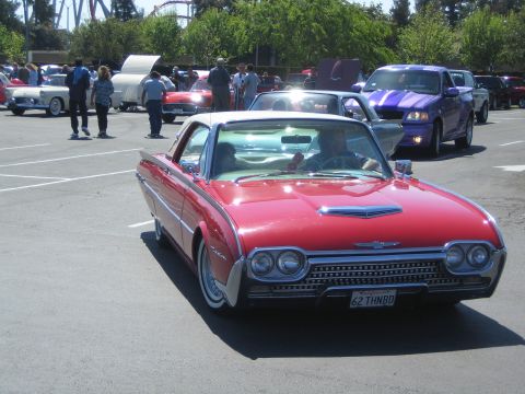1968 Ford Mustang - A red 1962 Ford Thunderbird convertible is parked in a lot with other vehicles and people.