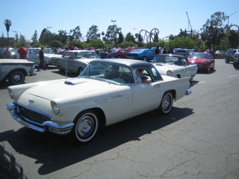 1968 Ford Mustang - A white 1957 Ford Thunderbird with a black hardtop is parked in a lot with other classic cars.