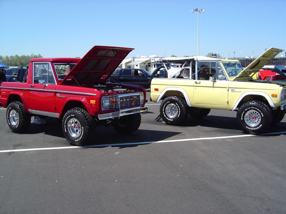 Red and yellow Ford Broncos parked with hoods open