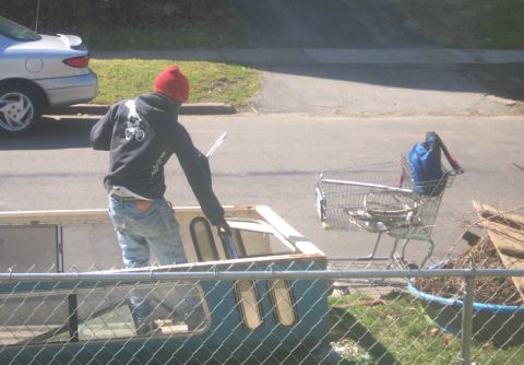 1979 Ford F-150 - A person is seen loading items into a camper shell, with a shopping cart filled with goods parked next to it.