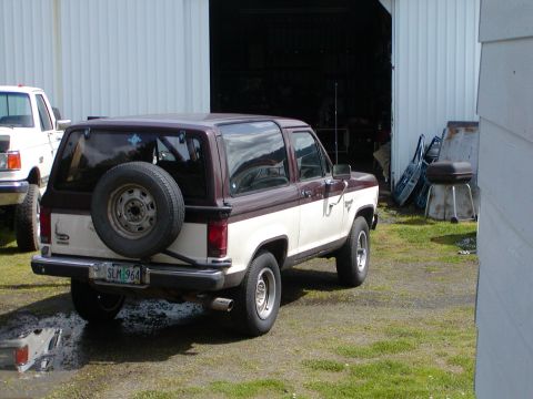 1987 Ford Bronco II - Rear view of a two-tone 1987 Ford Bronco II with a spare tire mounted on the back.