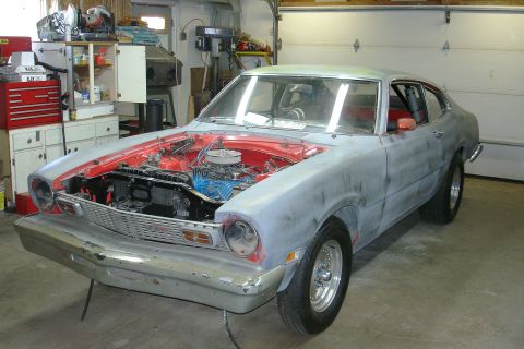 1981 Ford Mustang - A 1970 Ford Maverick coupe is undergoing restoration in a garage, showing its engine and red interior.