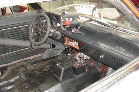 1981 Ford Mustang - The interior of a 1981 Ford Mustang shows racing modifications including a roll bar and auxiliary gauges.