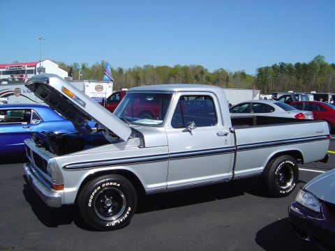 1986 Ford Bronco - Silver 1970 Ford F-100 pickup truck with hood open, parked outdoors with other vehicles.