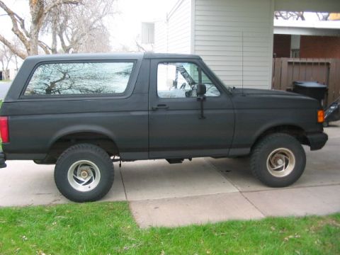 1991 Ford Bronco - Side profile of a matte black 1991 Ford Bronco.