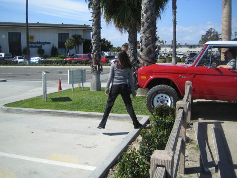1968 Ford Mustang - A red Ford Bronco is parked next to a woman. The vehicle appears to be from the late 1960s or early 1970s.