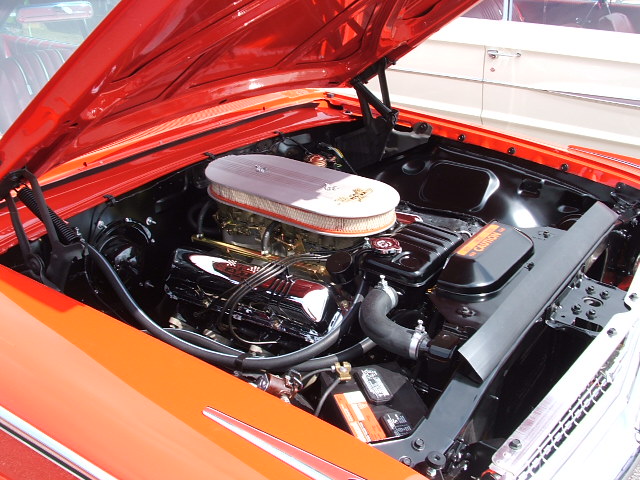 Engine bay with chrome accents and an air cleaner. A "Caution" label is visible