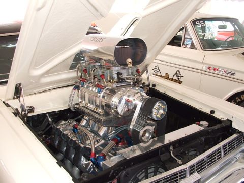 1966 Ford Ranchero - A highly customized 1966 Ford Ranchero features a polished supercharged V8 engine with a BDS intake, alongside another vehicle in the backg…