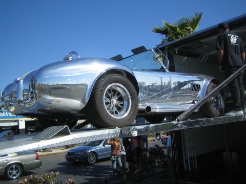1968 Ford Mustang - A gleaming chrome AC Cobra replica is loaded onto a car hauler, with a sign indicating it was at 'Fabulous Fords Forever '06'.