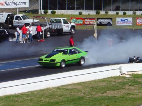 1986 Ford Bronco - A drag car performs a burnout, creating a large cloud of smoke on the race track.