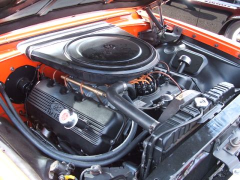 1966 Ford Ranchero - The engine bay of an orange 1966 Ford Ranchero, its V8 engine and air cleaner assembly.