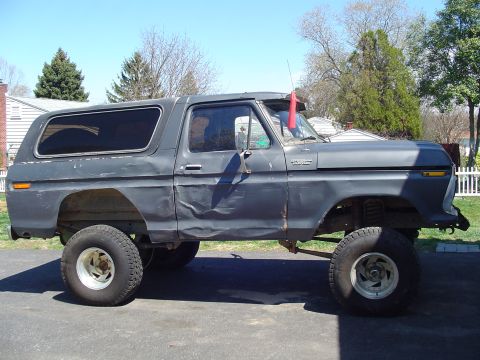1979 Ford Bronco - This 1979 Ford Bronco is a lifted SUV with significant body damage visible on its side panels.