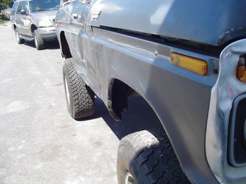 1979 Ford Bronco - Close-up side view of a 1979 Ford Bronco, showing its fender and large off-road tires.