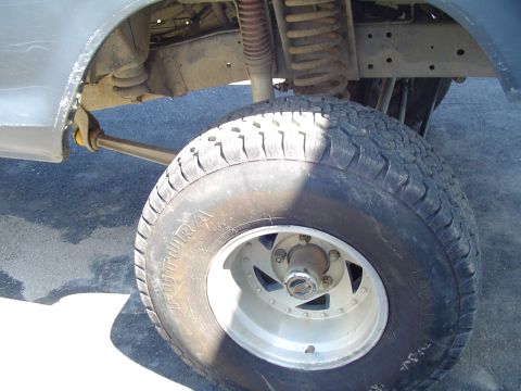 1979 Ford Bronco - This image focuses on the undercarriage of a vehicle, highlighting the tire and suspension system.