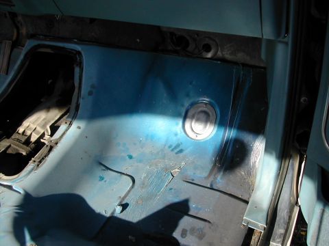 1981 Ford Bronco - The interior floor of a vehicle shows a blue painted surface with some wear and tear.