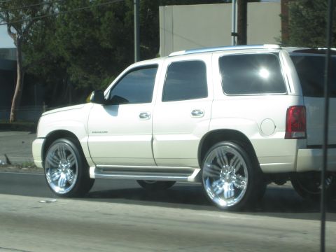 1968 Ford Mustang - A white SUV with large chrome wheels is seen from the side.