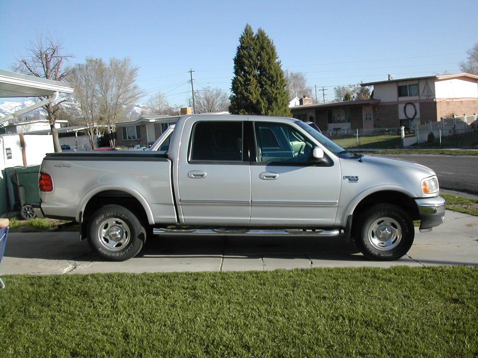 Silver four-door pickup truck parked on a driveway