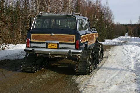 2003 Jeep TJ - This Jeep Grand Wagoneer, modified with tracks for snow travel, is seen from the rear on a winter road. The license plate reads CZJ-574.
