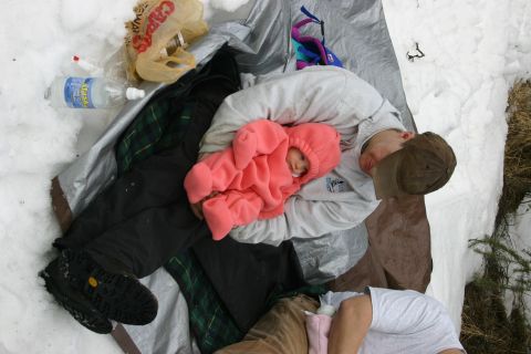 2003 Jeep TJ - A scene of people and camping gear in the snow, including a baby dressed in a pink snowsuit.