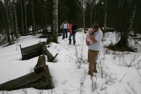 2003 Jeep TJ - A group of people walk through a snow-covered forest, passing by broken wooden structures.