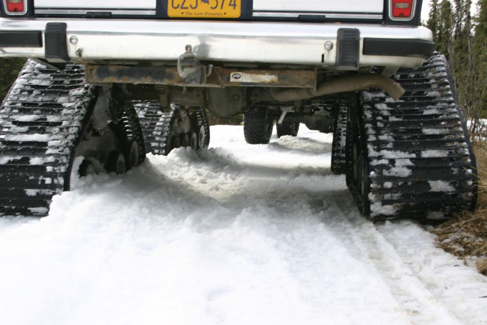 Rear view of a vehicle with snow tracks driving through snow. License plate CZS 574