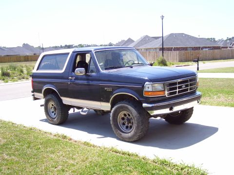 1992 Ford Bronco - This 1992 Ford Bronco features a dark blue exterior with a white removable top and a chrome grille.