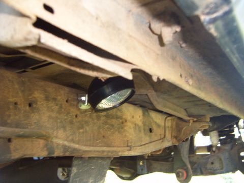 1988 Ford Bronco - Underside view of a vehicle frame with a rock light installed.