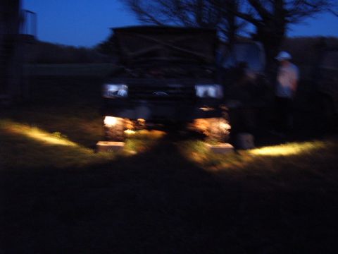 1988 Ford Bronco - A dark scene shows a 1980s Ford Bronco with its hood up and rock lights on.