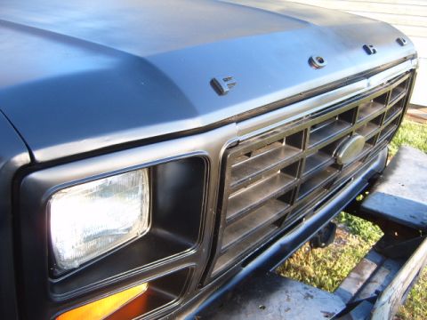 1988 Ford Bronco - Close-up of a Ford truck's front end, showing the grille and headlight assembly.