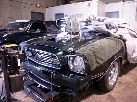2001 Mercury Grand Marquis - A heavily modified muscle car, likely from the mid-1970s, is prepped for dyno tuning, with another dark vehicle visible behind it.